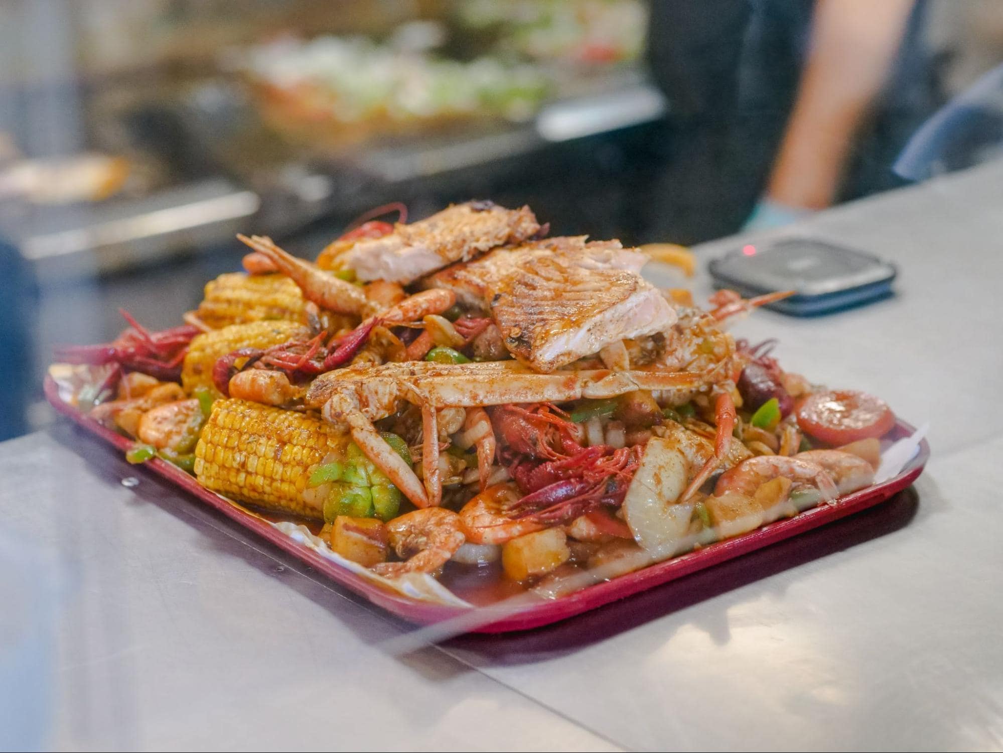  Freshly cooked seafood boil consisting of crab legs, shrimp, fish, corn and potatoes, among others.