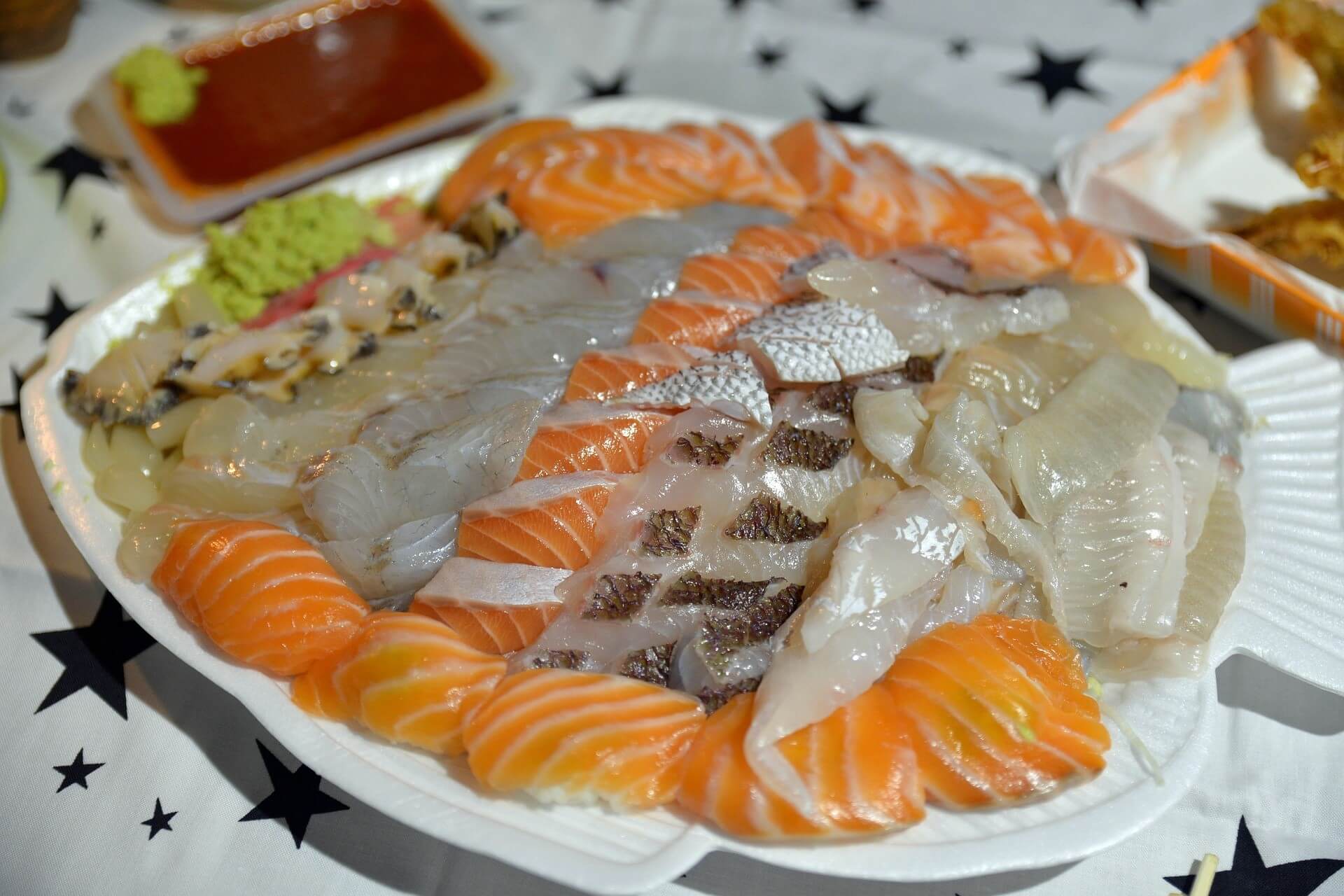 Sashimi is thinly sliced fresh fish served on a platter with dipping sauces