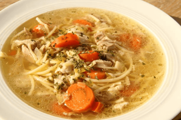 Comforting chicken noodle soup with carrots and parsley.