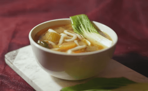 Comforting chicken noodle soup with carrots and parsley.